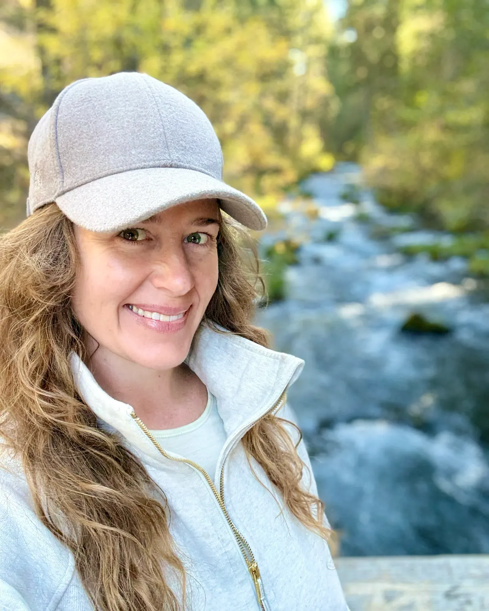 Katie Hamilton outdoors beside a creek in autumn daylight